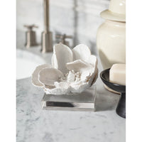 White magnolia bloom objet on a clear crystal base, 5" tall, on a marble counter.