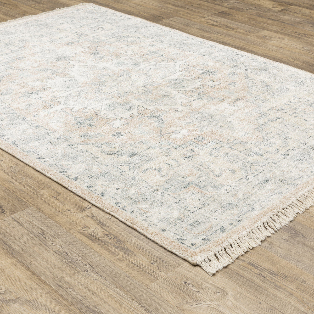Malabar Beige & Grey casual rug with subtle Persian designs and fringe, on a wood floor.