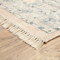Malabar Beige & Grey hand-loomed rug with subtle Persian designs and fringe on a wood floor.