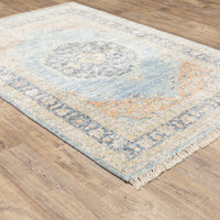 Hand-loomed Malabar Blue & Beige Traditional Rug with Persian designs and fringe on wood floor.