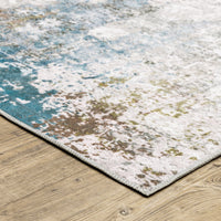 Malibu Ivory & Blue Washable Rug with abstract distressed design and blanket stitch finish on wood floor.