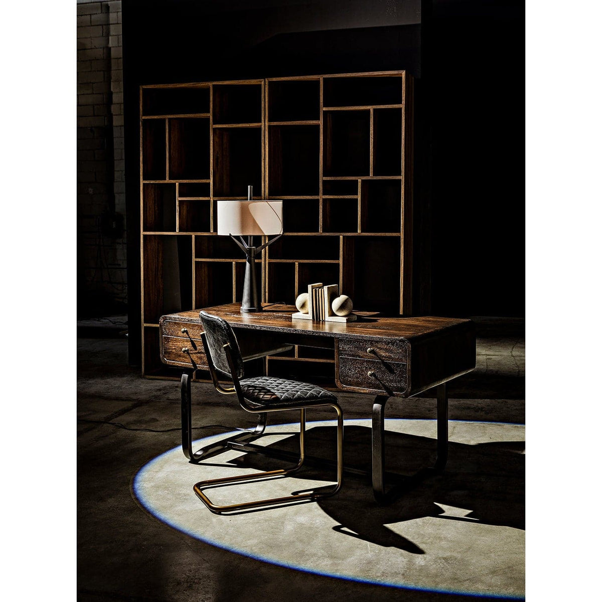 Malic Dark Walnut Bookshelf, 88"H, with varied cubbies behind a dark wood desk and chair.