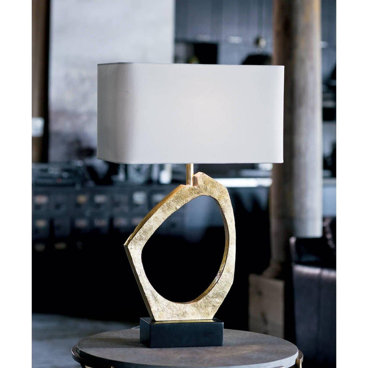 Manhattan Table Lamp with a sculptural gold leaf base, black pedestal, and rectangular linen shade.
