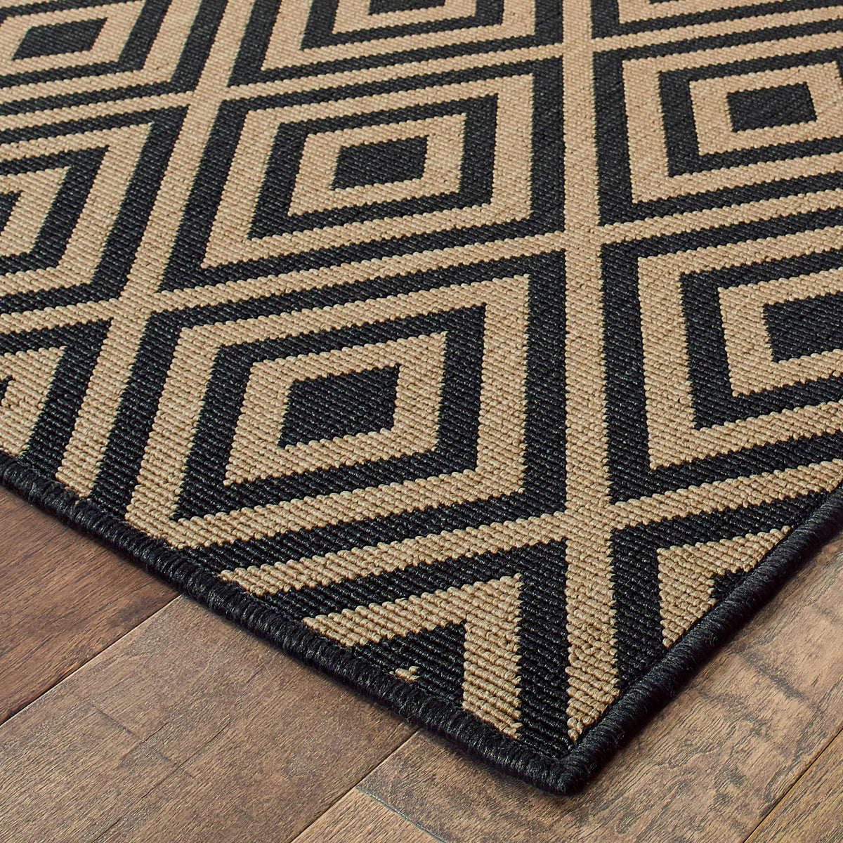 Marina Black & Tan outdoor rug with a geometric diamond pattern, made of durable polypropylene.