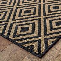 Marina Black & Tan outdoor rug with a geometric diamond pattern, made of durable polypropylene.