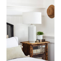 Markus 28.5" white ceramic table lamp with freckled pattern, polished nickel accents, and natural linen drum shade on a rattan nightstand.