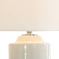 Markus 28.5" ceramic table lamp with a freckled neutral body, polished nickel accents, and a crisp natural linen drum shade.