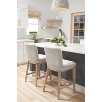 Two white mesh woven rope counter stools with solid wood legs at a kitchen island.