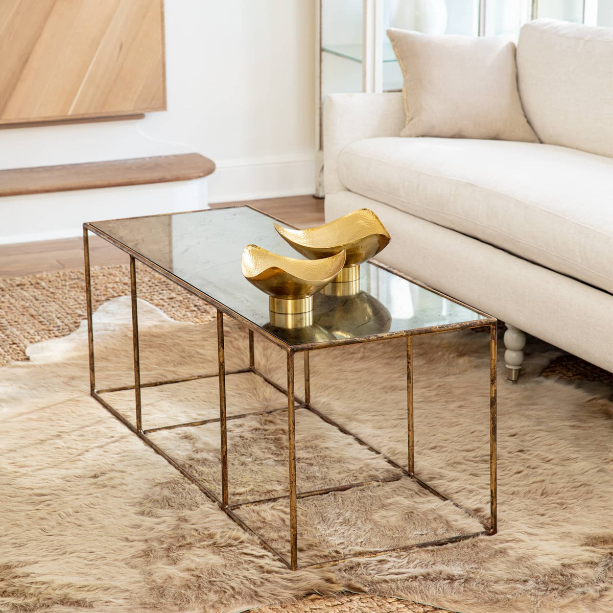Milo Large Brass Decorative Bowl, polished golden tone with hand-hammered texture, on a coffee table.