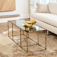 Milo Large Brass Decorative Bowl, polished golden tone with hand-hammered texture, on a coffee table.