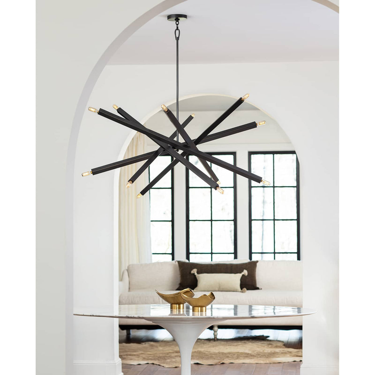 Two Milo Large Brass Decorative Bowls on a white tulip table in a modern living space.