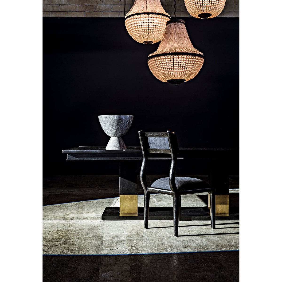 Black steel Mist Chandelier with beaded glass shades, illuminating a dining table and chair.