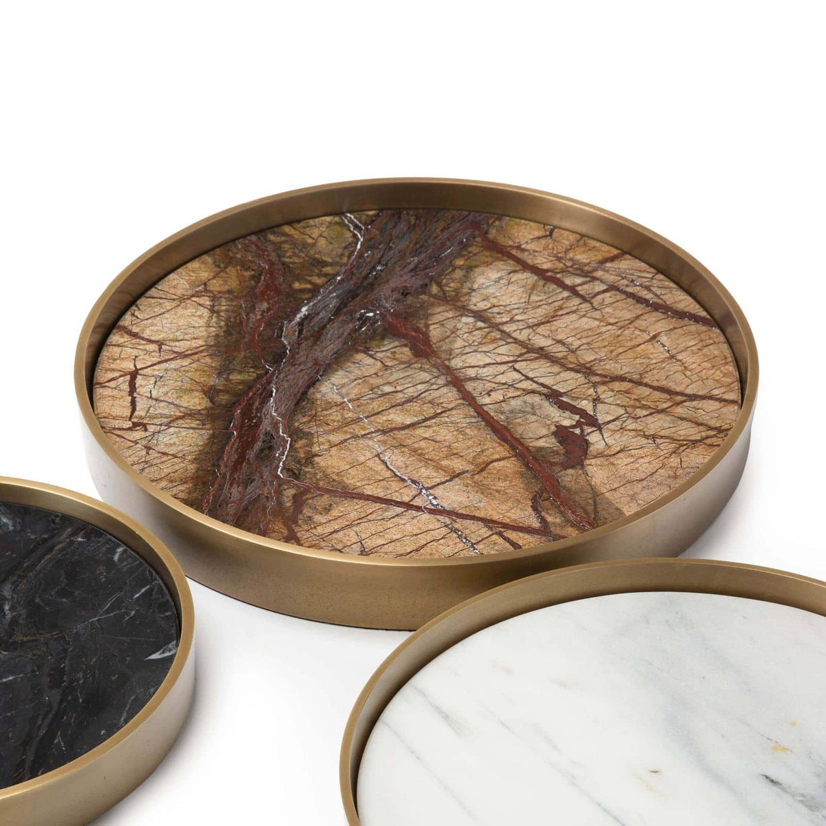 Set of three round marble trays in varied shades (brown, black, white) with natural brass frames.