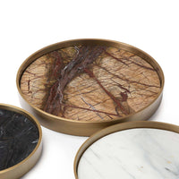 Set of three round marble trays in varied shades (brown, black, white) with natural brass frames.