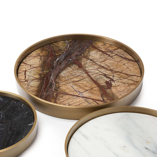 Set of three round marble trays in varied shades (brown, black, white) with natural brass frames.