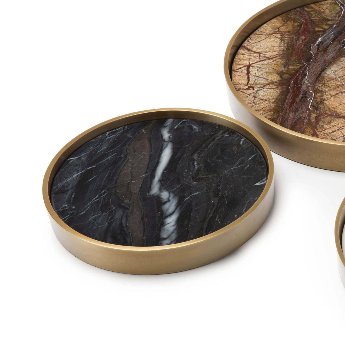 Set of three round marble trays with natural brass frames, featuring unique black and brown veining.