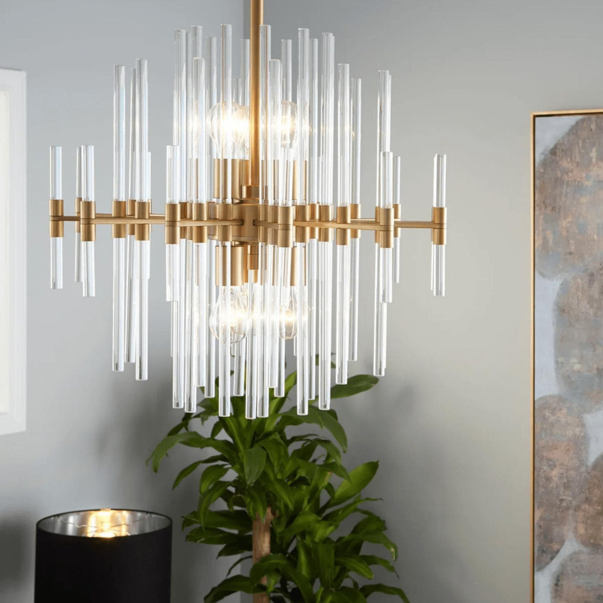 Small Montreal aged brass chandelier with linear design and varying length glass rods.