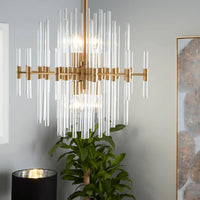Small Montreal aged brass chandelier with linear design and varying length glass rods.