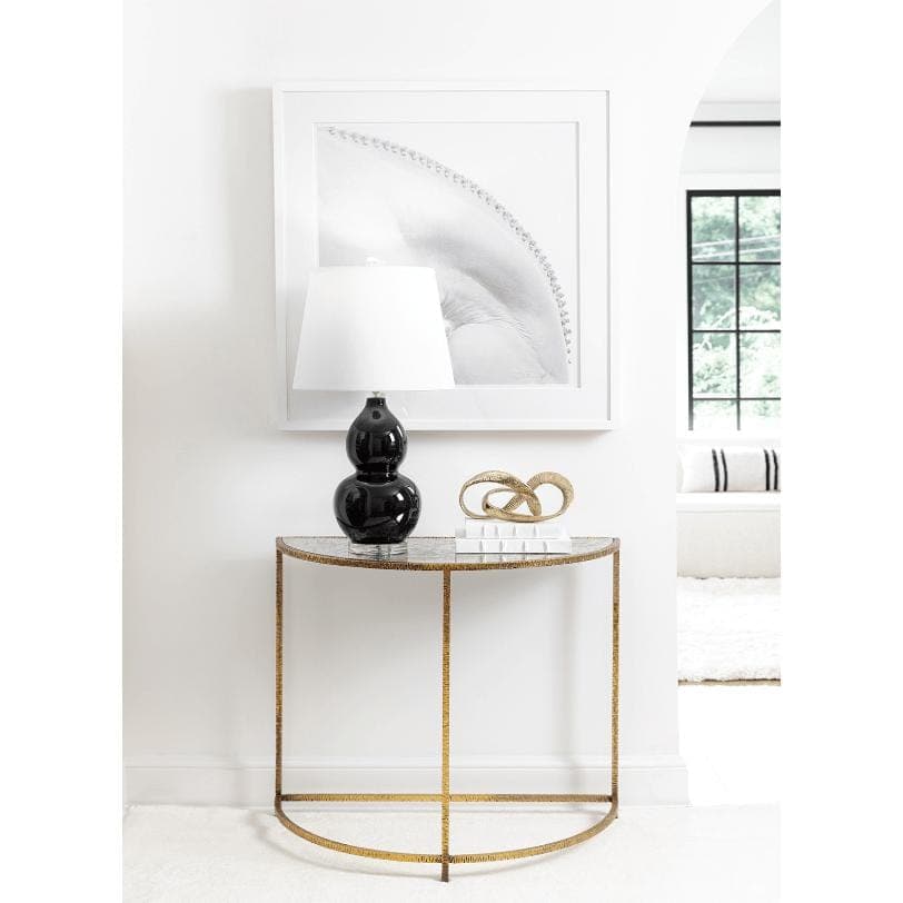 Myriad Infinity Gold Metal Sculpture on a console table, a continuous loop of solid brass.