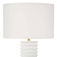 White Nabu metal column table lamp with accordion-like base and linen shade.