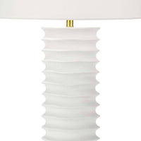 White Nabu metal column table lamp with an accordion-like base and a simple linen shade.