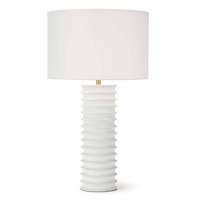 White Nabu metal column table lamp with accordion-like base and linen shade.