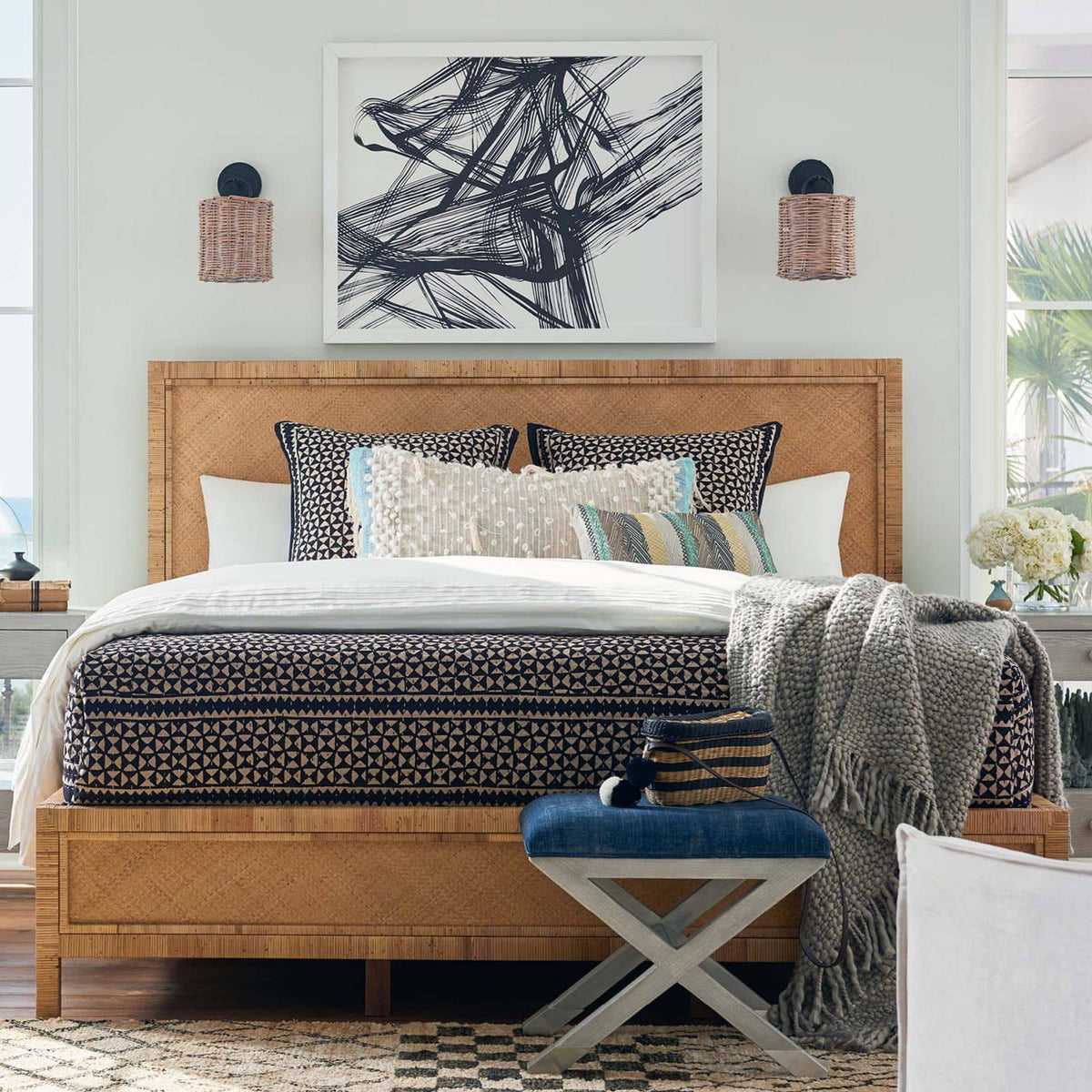 Nantucket Sconce with handwoven rattan shade and oil-rubbed bronze backplate, flanking a bed.