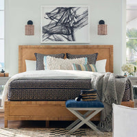 Nantucket Sconce with handwoven rattan shade and oil-rubbed bronze backplate, flanking a bed.