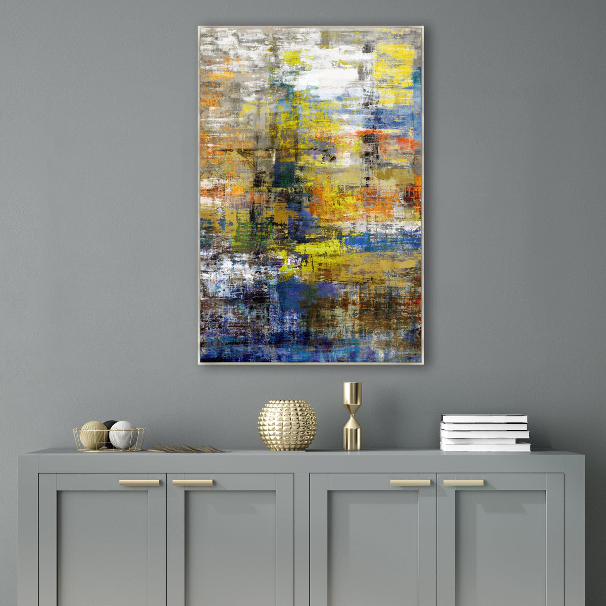 Abstract giclee canvas painting with vibrant yellow, blue, and orange strokes, framed above a gray cabinet.