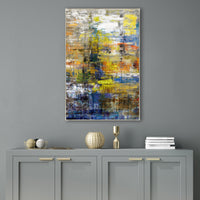 Abstract giclee canvas painting with vibrant yellow, blue, and orange strokes, framed above a gray cabinet.