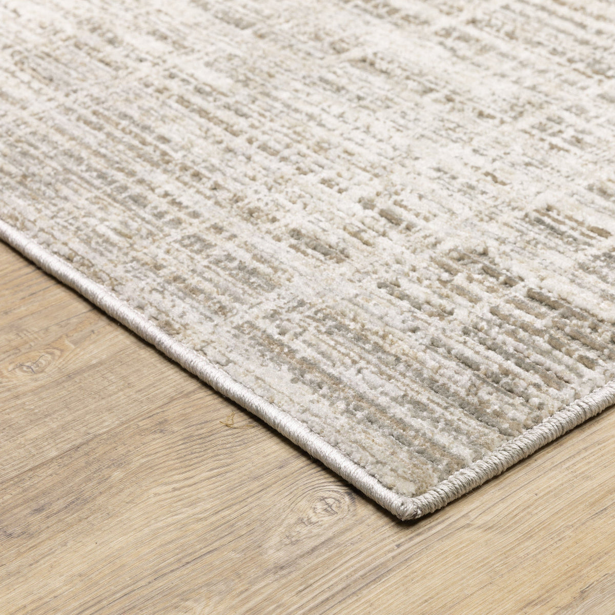 Nebulous Beige & Ivory Abstract Rug with a low-profile, textured polyester design on a light wood floor.