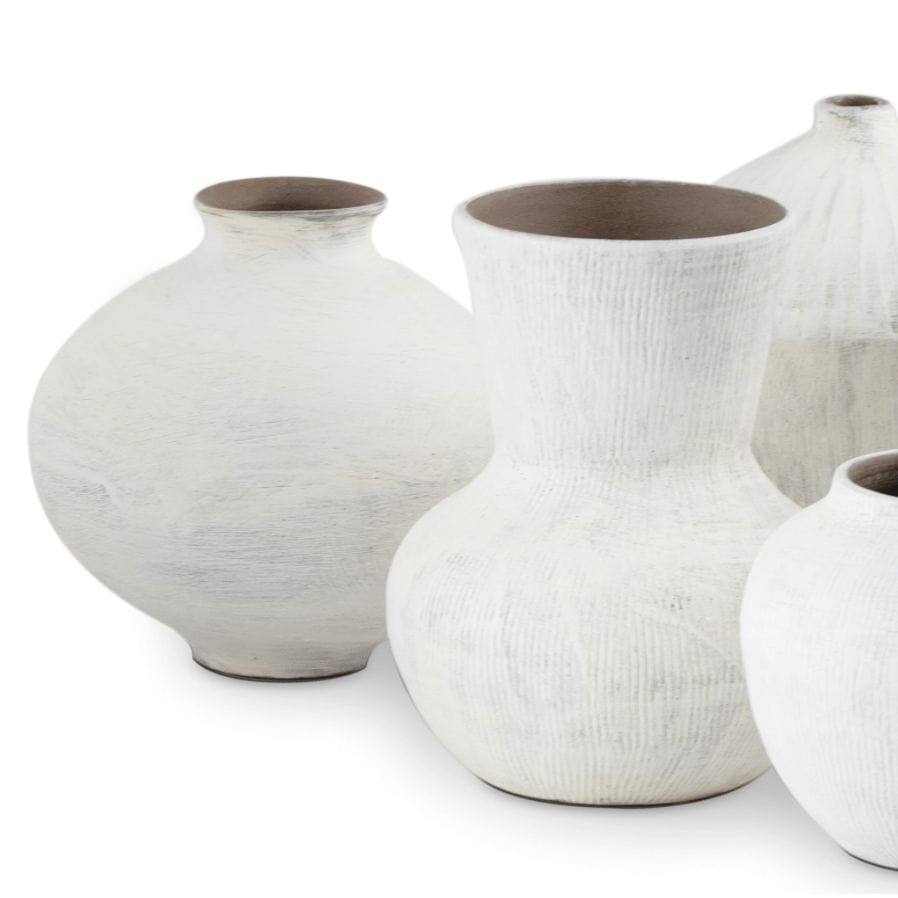 Set of five organic white ceramic vases with handmade textures and varying shapes.