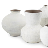 Set of five organic white ceramic vases with handmade textures and varying shapes.