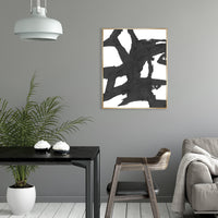 Obsidian III Giclee Canvas Painting: Abstract black brushstrokes on white, framed in gold, in a modern interior.