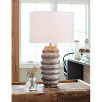 Ola ceramic table lamp with an organic, ribbed earthen brown body, aged brass base, and natural linen drum shade.