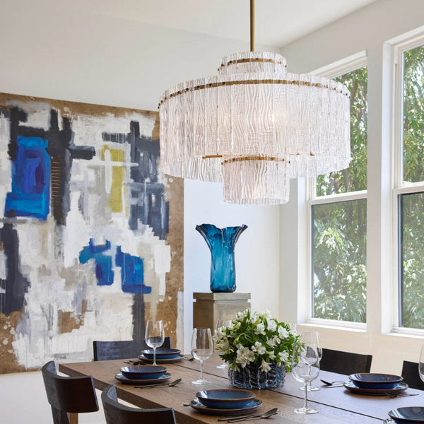 Orinder 9-light aged brass chandelier with hand-pressed textured glass panels, illuminating a dining room.