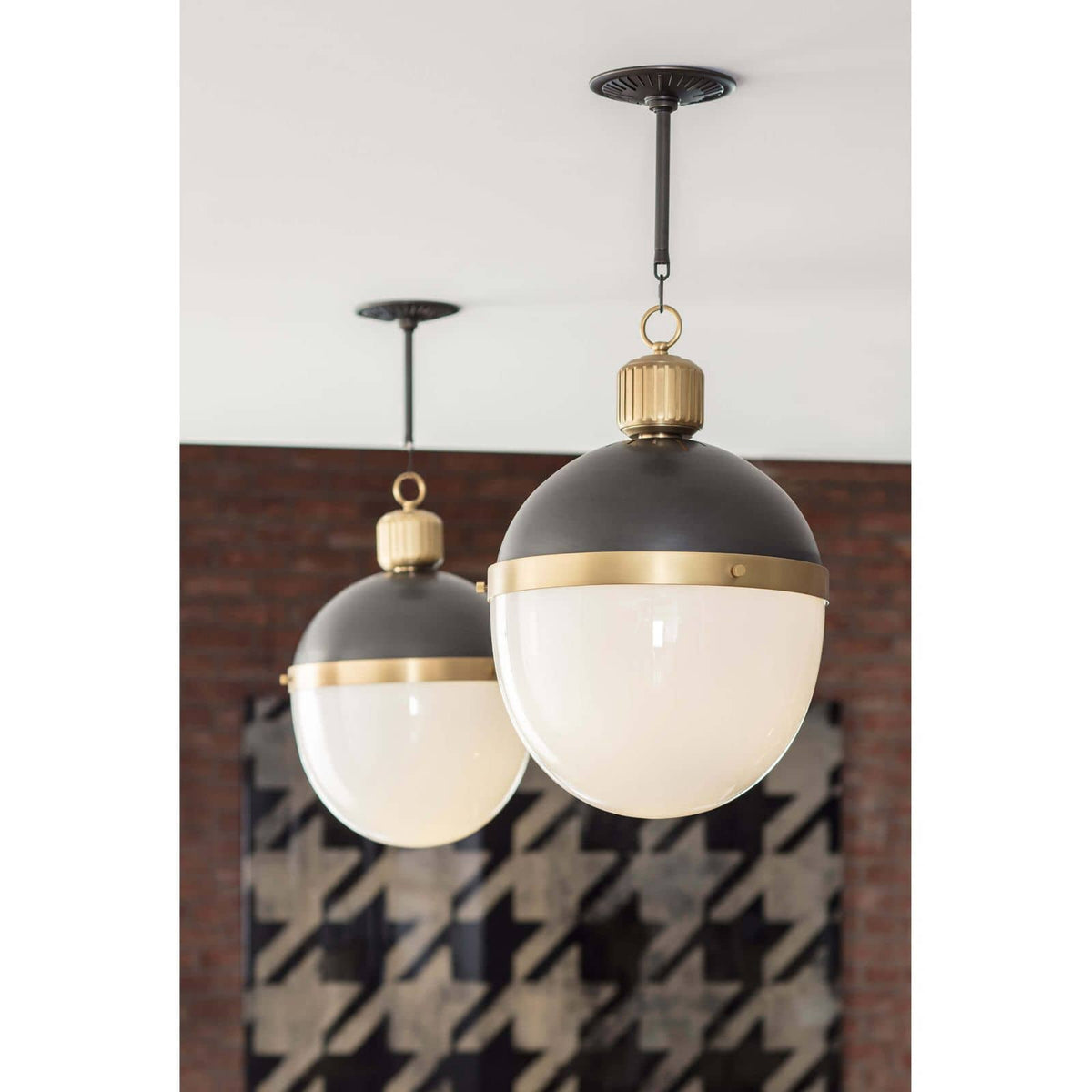Two Otis large blackened natural brass pendants with translucent white milk glass globes.