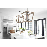 Two Perennial Lantern Natural chandeliers with wood beads and faux drip wax candle sleeves hang in a modern kitchen.