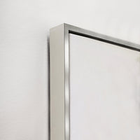Close-up of a giclee canvas artwork with a sleek silver floating frame against a white wall.