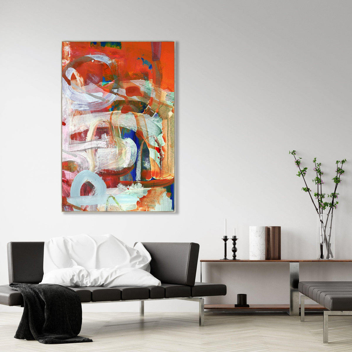 Abstract giclee canvas painting "Play It Right" with vibrant red, white, and blue brushstrokes, displayed above a black leather sofa.