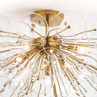 Poppy semi-flush mount light with natural brass rods and undulating clear glass discs.