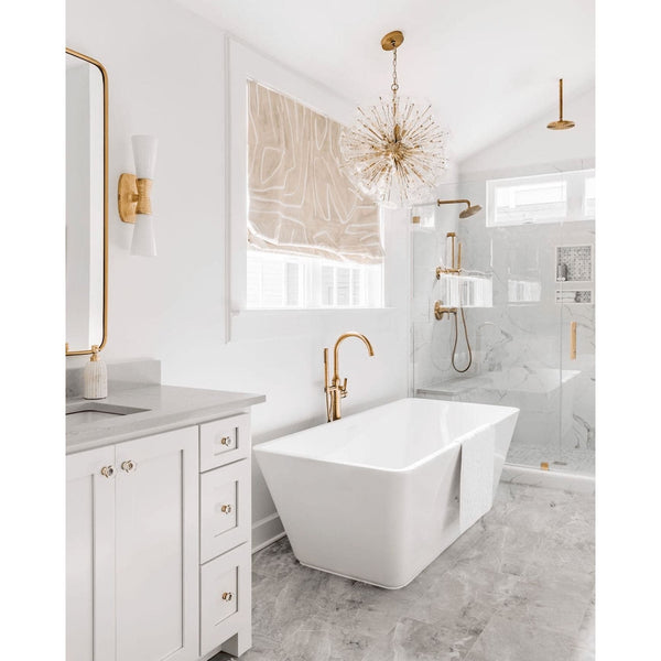 Poppy sputnik-style orb chandelier with clear glass discs and natural brass rods in a modern white bathroom.