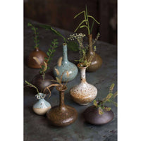 Eclectic set of 8 handmade porcelain bud vases in varying shapes, sizes, and colors, from blue to brown.