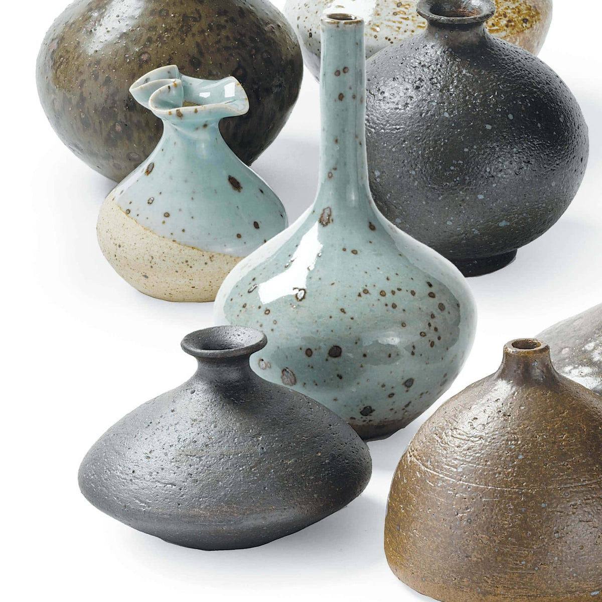 Set of 8 eclectic porcelain bud vases in varying shapes, sizes, and colors like robin's egg blue and warm browns.