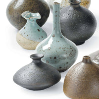 Set of 8 eclectic porcelain bud vases in varying shapes, sizes, and colors like robin's egg blue and warm browns.