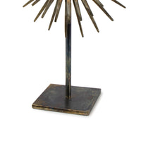Radiant Sculpture: Industrial-chic patinated iron base with spiked mirror surround.
