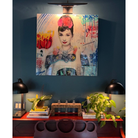 Large oil-rubbed bronze Redford picture light illuminating a colorful Audrey Hepburn artwork above a desk.