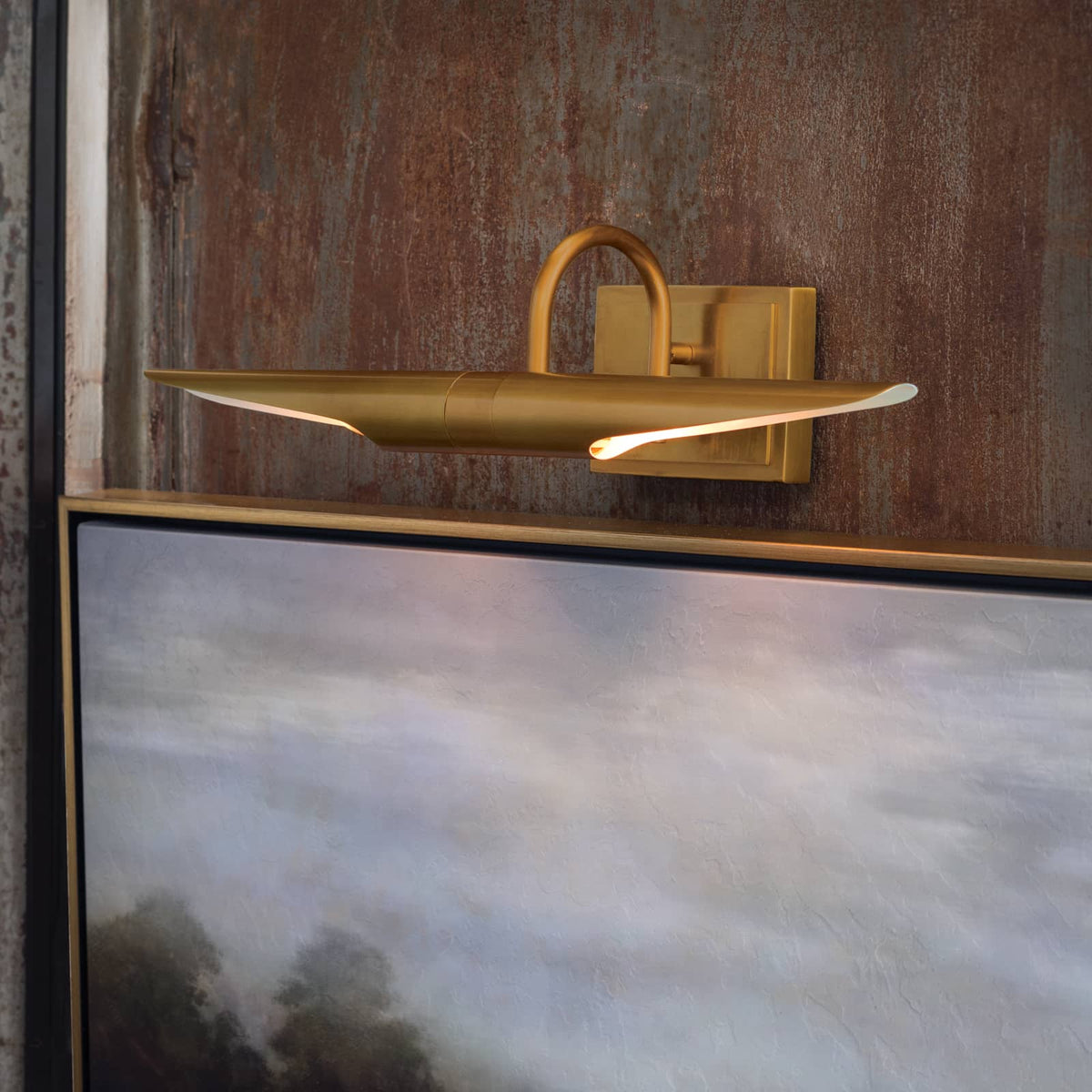 Redford Small Natural Brass Picture Light illuminating artwork, featuring a classic museum-inspired design.
