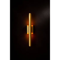 Redford Sconce in natural brass, a modern 22" tall steel wall light with warm glow.
