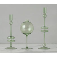 Sage green glass wine glass vase with a spherical body and two matching candle holders.